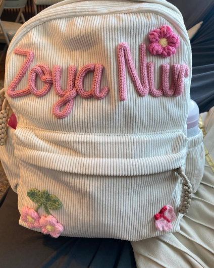 Cream backpack embroidered 'Zoya Nur' in pink with flower charms